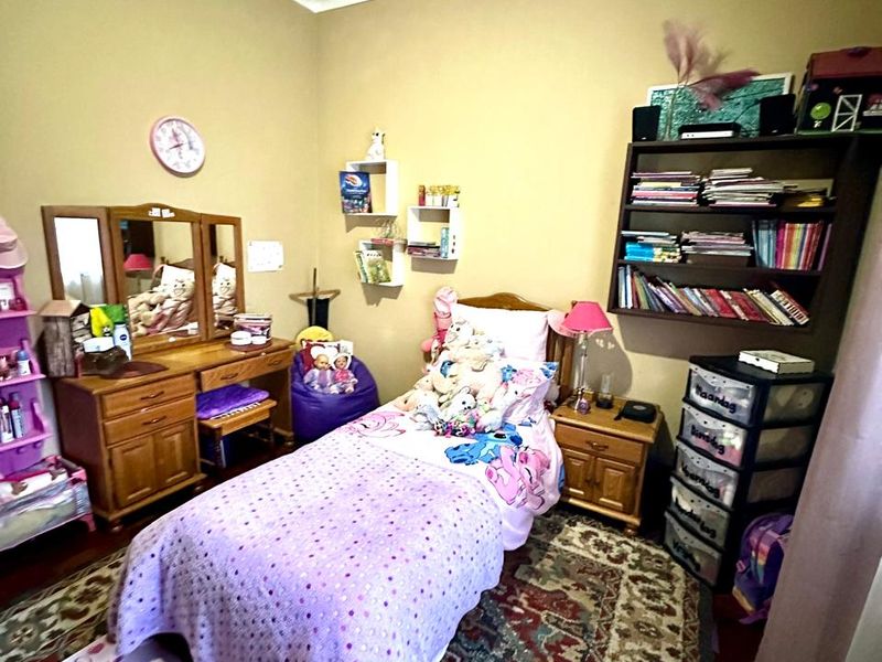 A bedroom featuring high ceilings with visible water damage and staining, requiring maintenance and cosmetic repair to restore the ceiling finish.