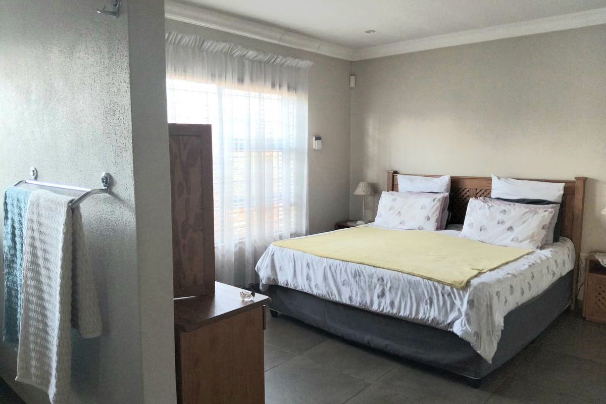 A bedroom featuring tiled flooring, a coved ceiling, and an integrated partition wall with a built-in towel rail.
