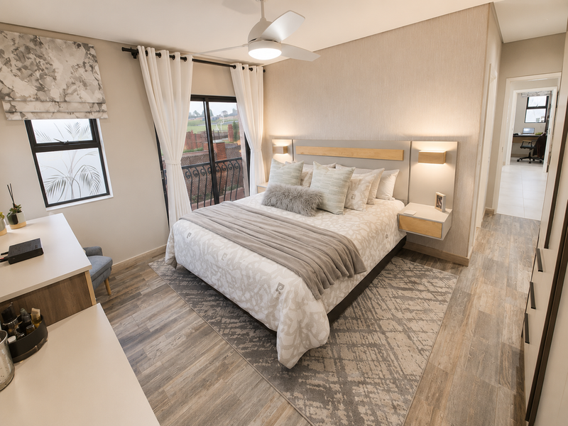A well-appointed bedroom featuring modern laminate flooring, a built-in headboard with integrated floating nightstands, recessed lighting, and a sliding door leading to a balcony.