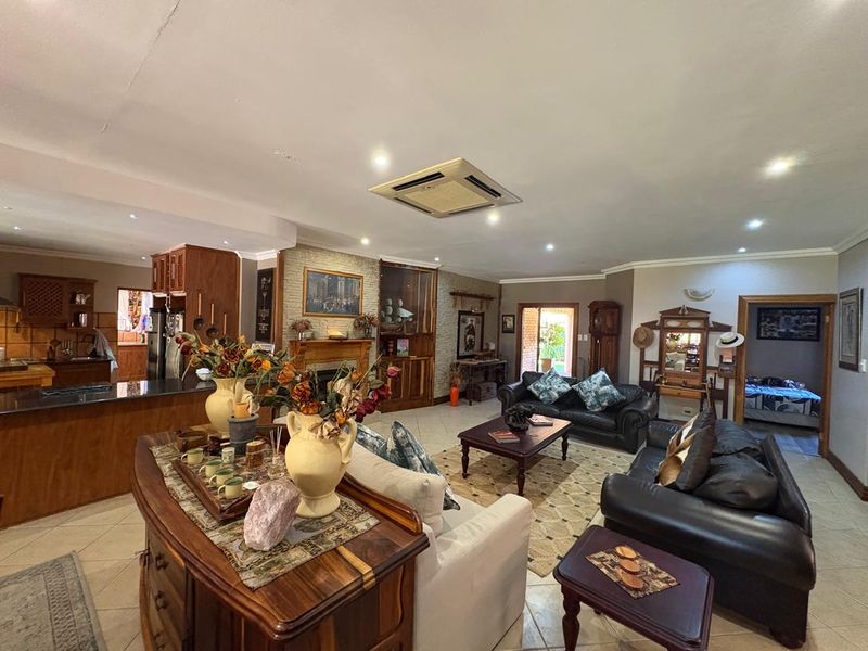 Spacious open-plan living area featuring a kitchen with granite countertops, a built-in fireplace, and integrated ceiling air conditioning.