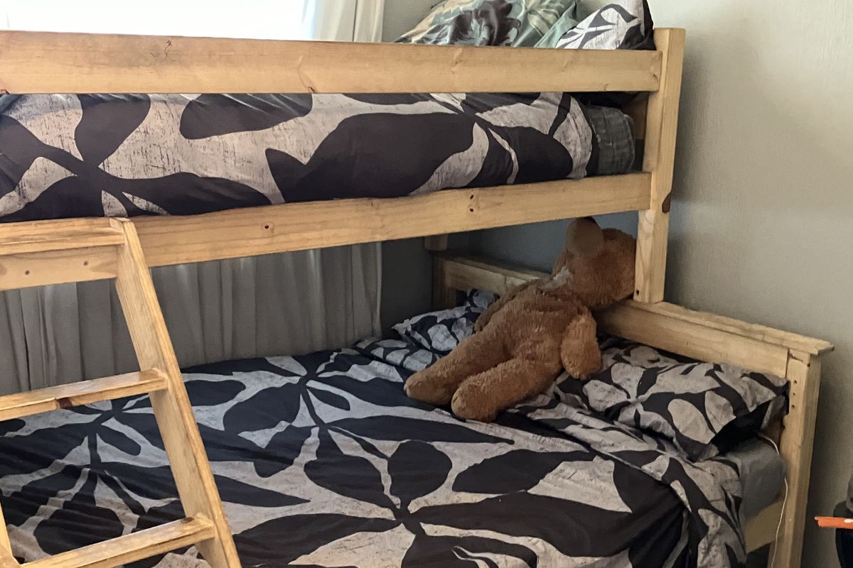 A bedroom space featuring a wooden bunk bed setup.