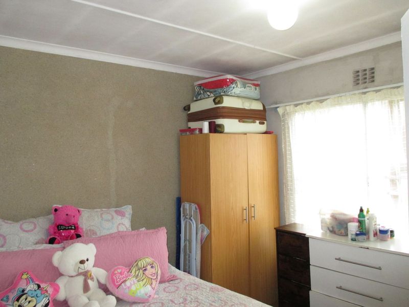 A bedroom featuring a window with natural light, standard ceiling with cornice, and unfinished wall surfaces.
