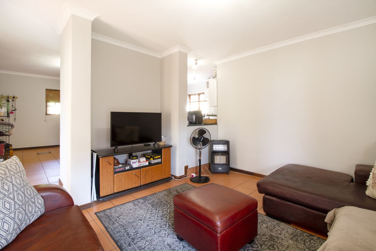 A comfortable living room featuring tiled flooring and classic cornicing, providing a neutral base for your personal interior design style.