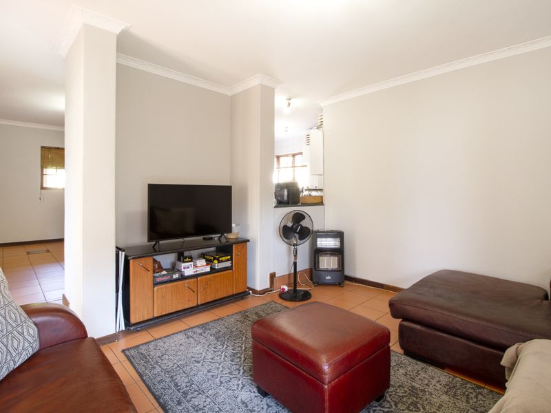 A comfortable living room featuring tiled flooring and classic cornicing, providing a neutral base for your personal interior design style.