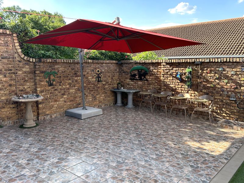 A paved outdoor patio area enclosed by a face brick boundary wall, providing a private space for outdoor seating and relaxation.