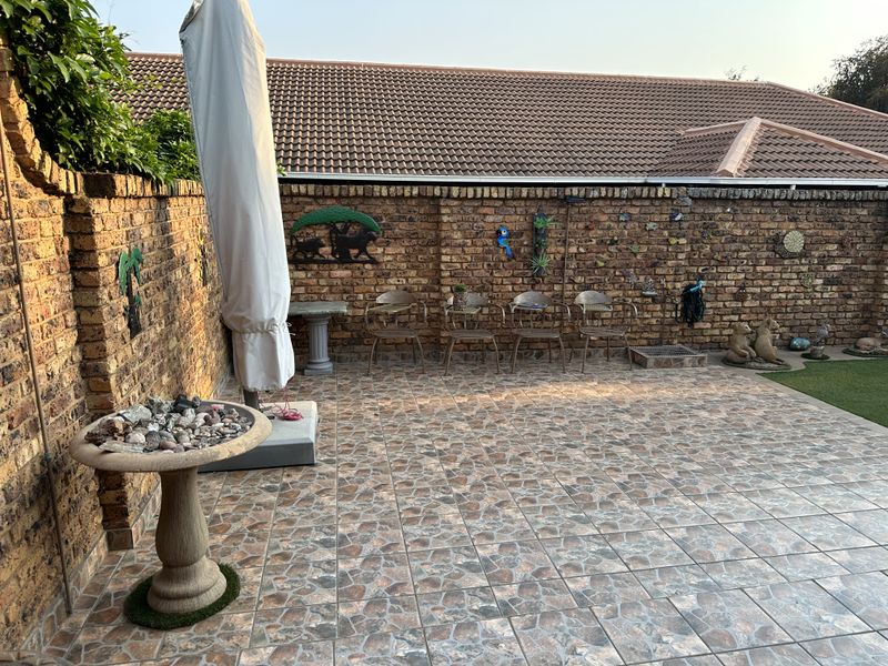 A private outdoor patio area featuring durable tiled flooring and enclosed by established facebrick boundary walls under a pitched tiled roof.