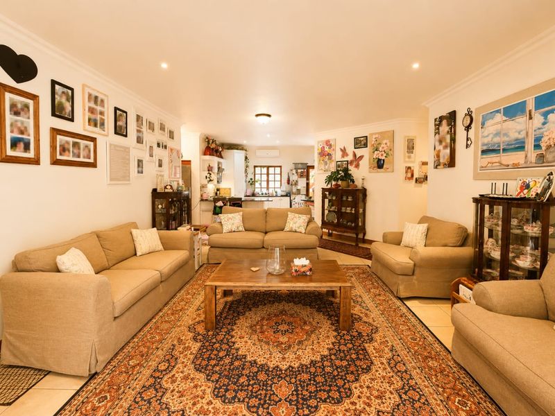 Spacious open-plan living area featuring tiled floors, recessed lighting, and an integrated kitchen space, offering a comfortable and functional layout.
