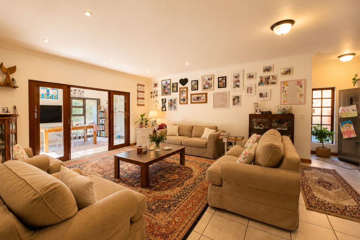 Spacious living room featuring tiled flooring, recessed lighting, and large sliding glass doors that provide seamless access to an adjoining sunroom or patio area.