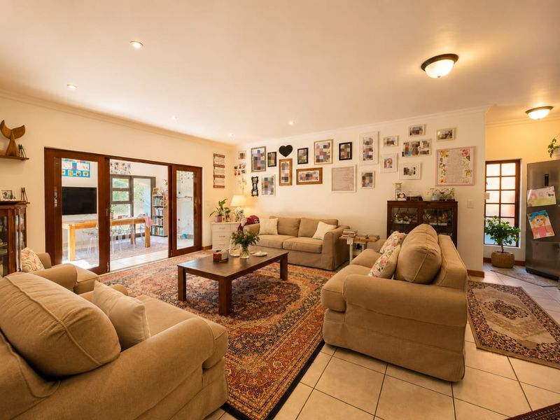 Spacious living room featuring tiled flooring, recessed lighting, and large sliding glass doors that provide seamless access to an adjoining sunroom or patio area.