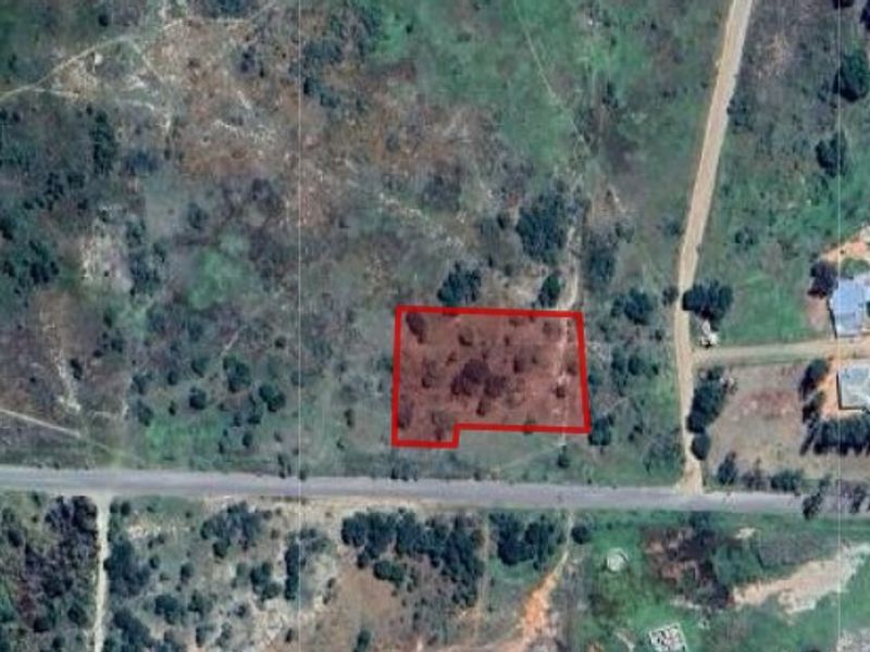 An aerial view of a vacant residential plot of land, showing its location and boundaries relative to the surrounding area.