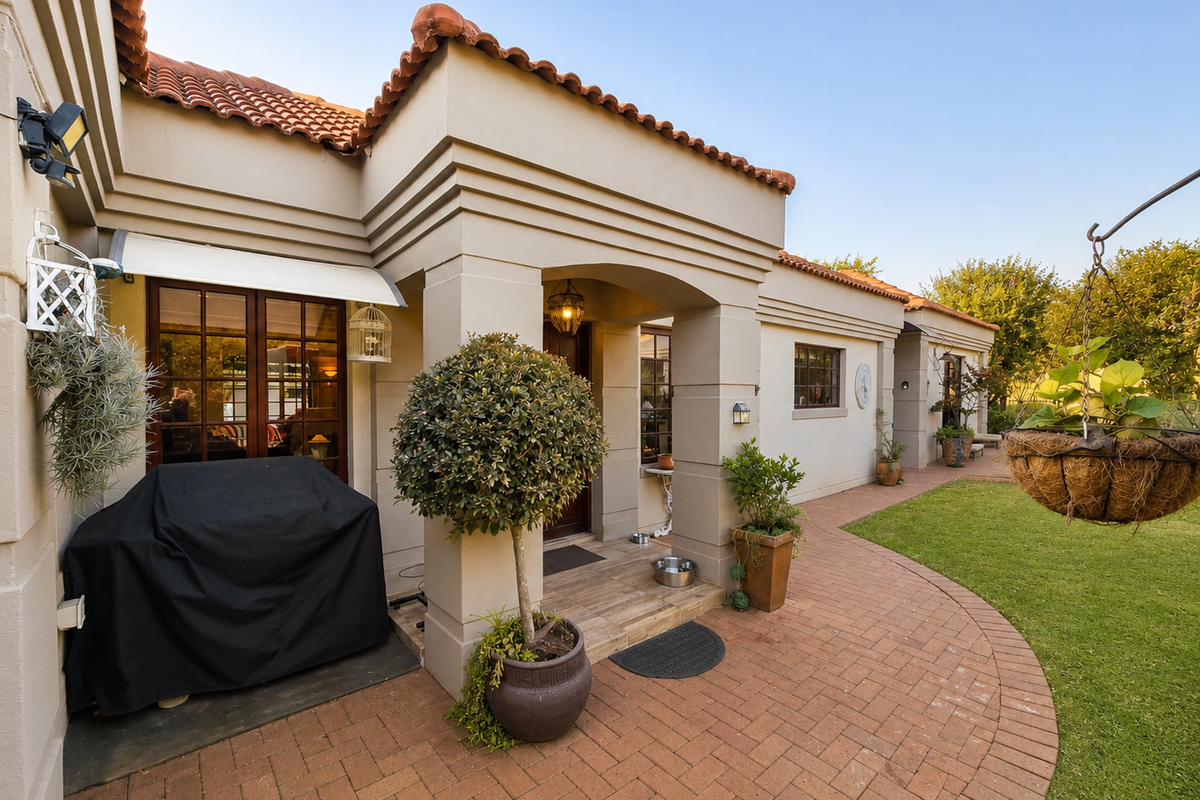 A well-maintained rear patio area featuring brick paving, terracotta roof tiles, and direct access to the garden through timber-framed glass doors.