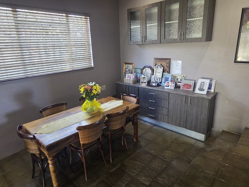 Dining room featuring tiled flooring, built-in wall cabinetry, and a window with venetian blinds.