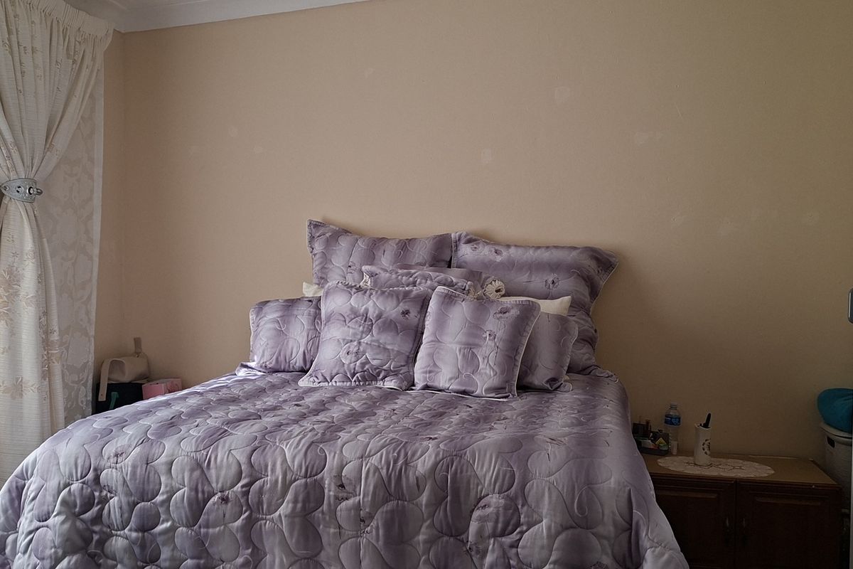 A standard bedroom featuring a built-in wardrobe and neutral wall finishes, providing a functional space for rest.
