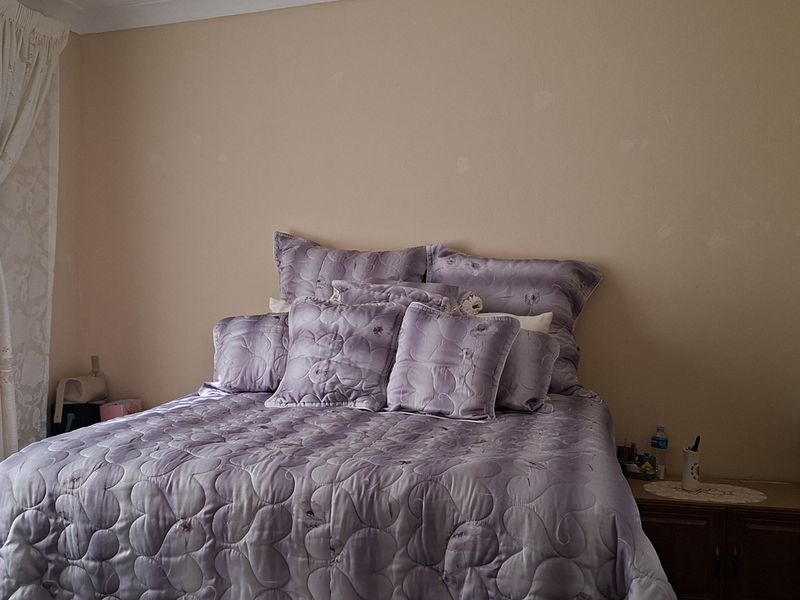 A standard bedroom featuring a built-in wardrobe and neutral wall finishes, providing a functional space for rest.
