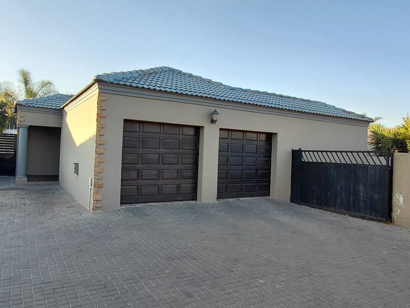 A well-maintained double garage with a tiled roof, paved driveway, and secure boundary walling, providing convenient off-street parking.