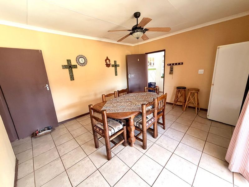 A functional dining room featuring tiled flooring, a ceiling fan, and neutral wall finishes, providing a practical space for family meals.