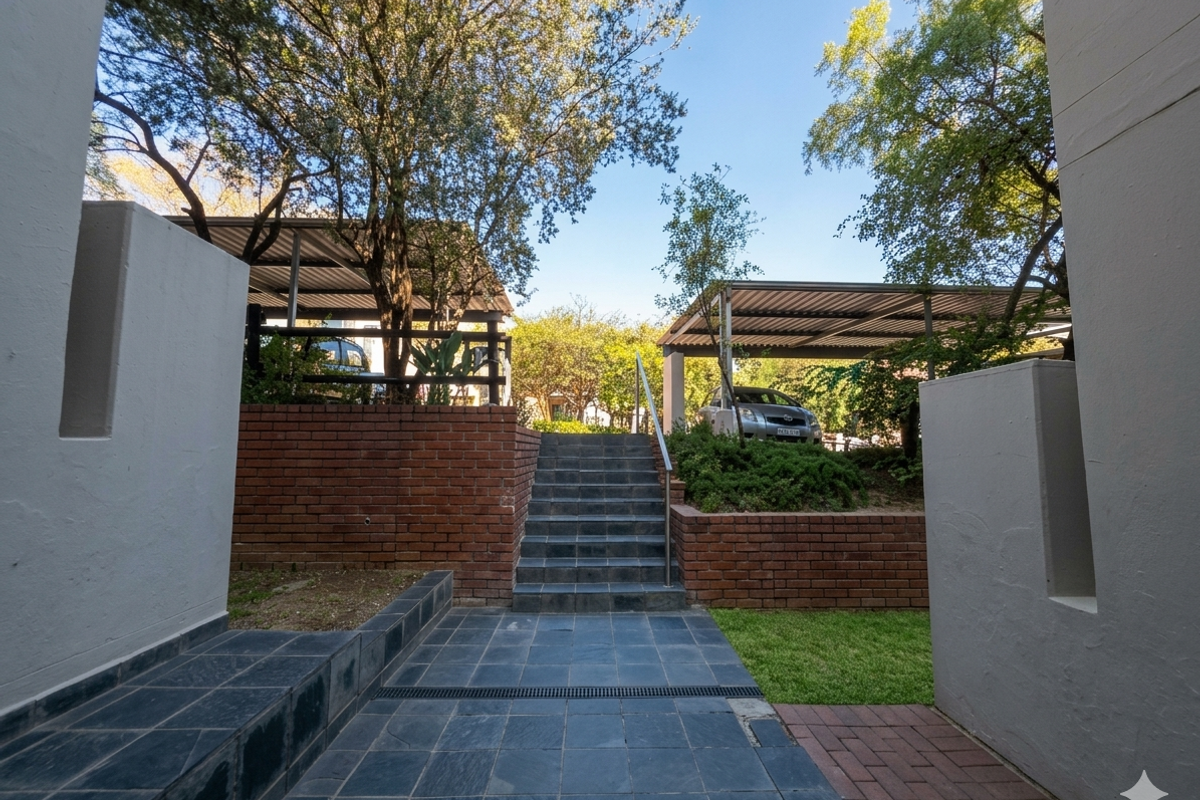 Rear exterior area featuring a tiled staircase, brick retaining walls, and covered carport parking spaces with paved access.