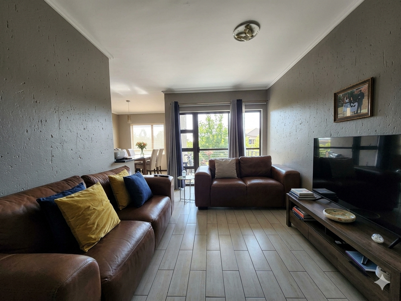 Open-plan living area featuring tiled flooring, textured walls, and a sliding glass door leading to an outdoor space.