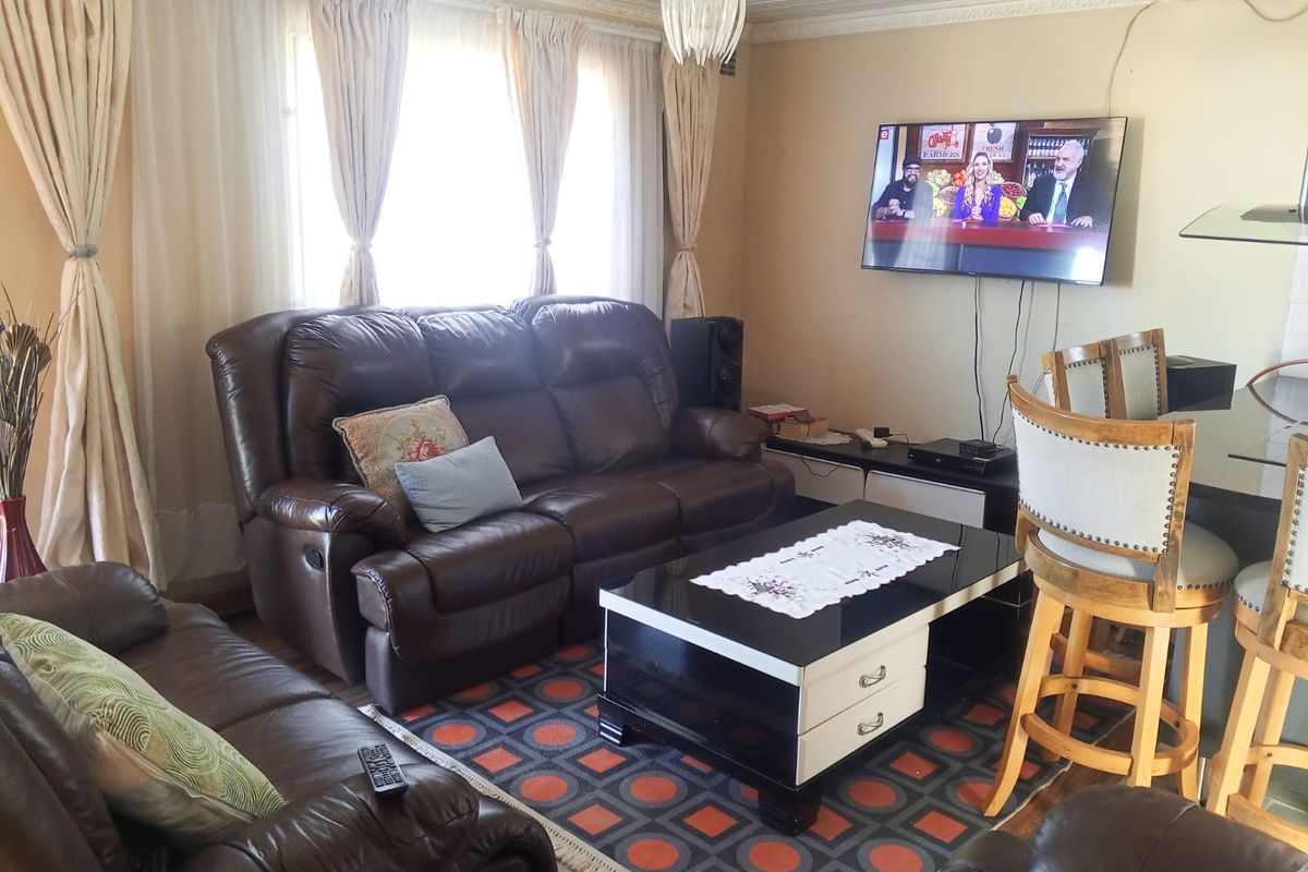 A living room featuring a tongue and groove ceiling, coving, and a wall-mounted television.