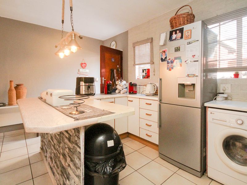 A functional kitchen featuring built-in cabinetry, a central island, and tiled flooring, providing a practical layout for daily meal preparation.