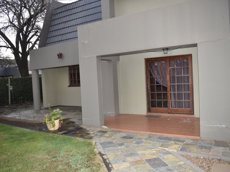 A covered patio area featuring tiled flooring, slate paving, and a sliding glass door entrance to the home.