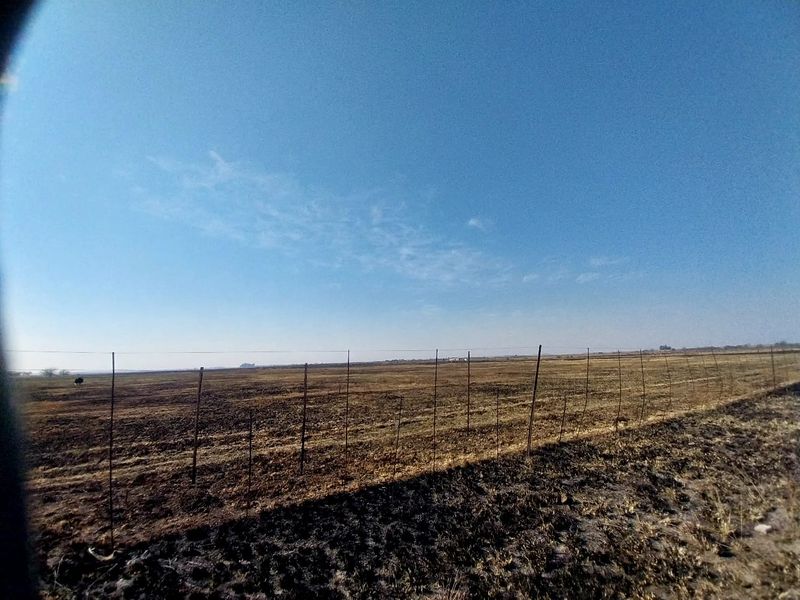 Expansive open land area featuring wire fencing, suitable for agricultural or small holding use.