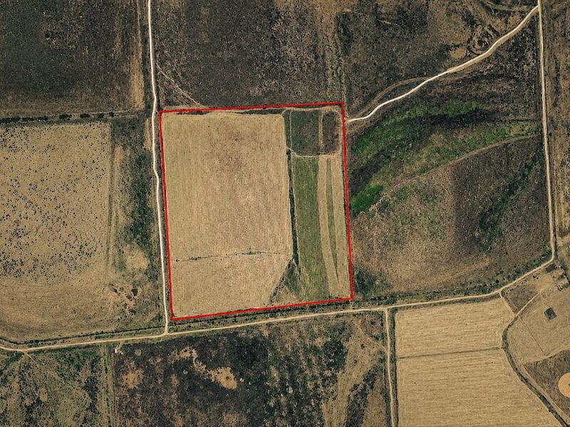 Aerial view of a rural small holding plot with defined boundaries and surrounding access roads.