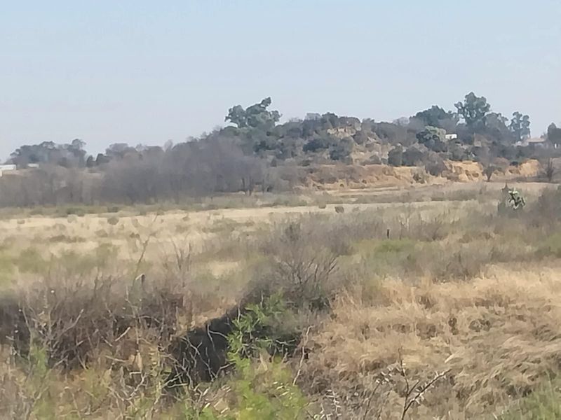 A wide-angle view of the natural landscape and surrounding terrain on the small holding property.