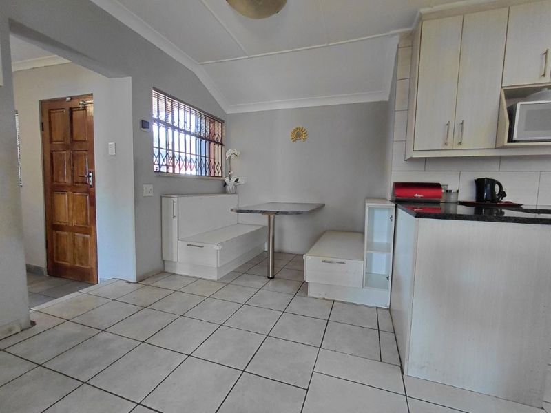 Kitchen featuring built-in cabinetry, granite countertops, and a built-in breakfast nook with tiled flooring.