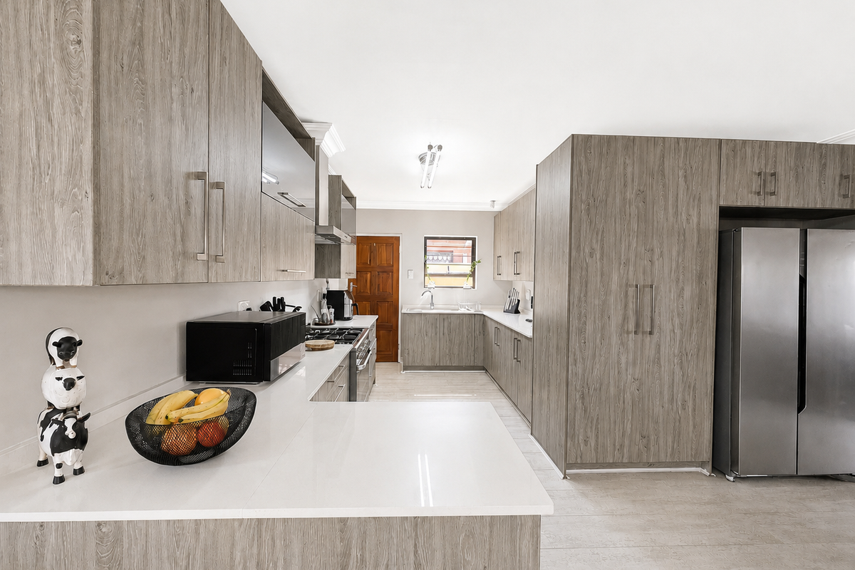 Modern kitchen featuring wood-grain cabinetry, stone countertops, integrated appliances, and a functional layout with ample storage and workspace.