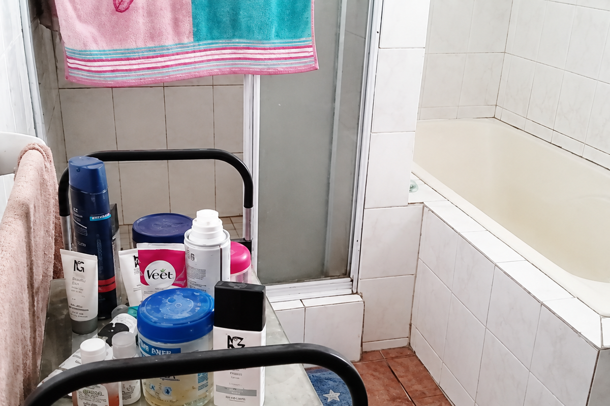 A dated bathroom featuring a built-in bathtub, separate shower enclosure, and tiled finishes, offering potential for modernization and renovation.