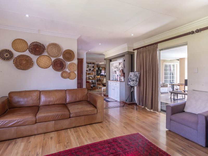 Spacious living room featuring laminate flooring, recessed lighting, and a sliding glass door providing access to an adjoining patio area.