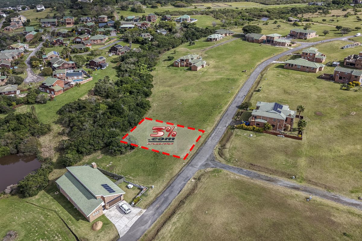 Aerial view of a vacant residential plot situated within a developed estate, featuring road access and surrounding established homes.