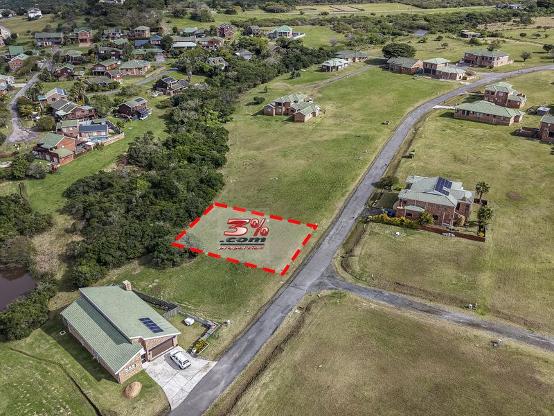 Aerial view of a vacant residential plot situated within a developed estate, featuring road access and surrounding established homes.