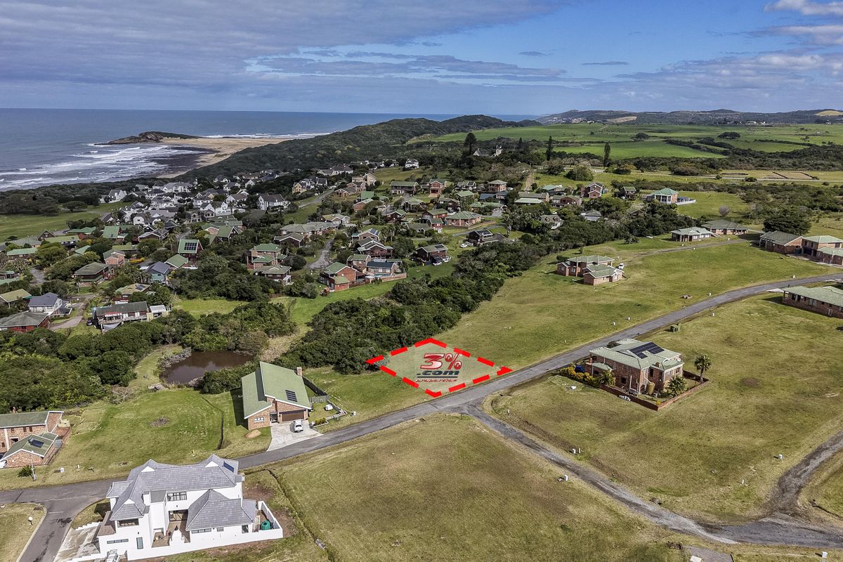 Aerial view of a vacant residential plot situated in a coastal estate with established infrastructure and proximity to the ocean.