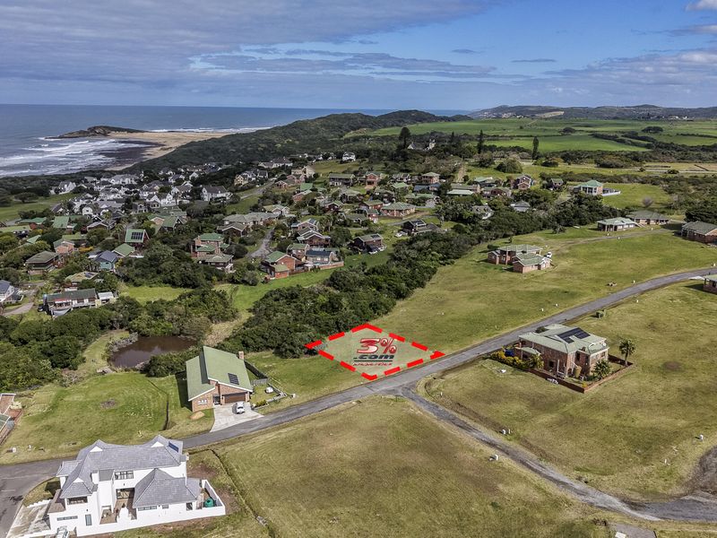 Aerial view of a vacant residential plot situated in a coastal estate with established infrastructure and proximity to the ocean.