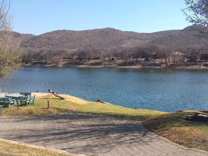 Scenic view of the river and surrounding landscape from the property, featuring a paved driveway area leading towards the water's edge.