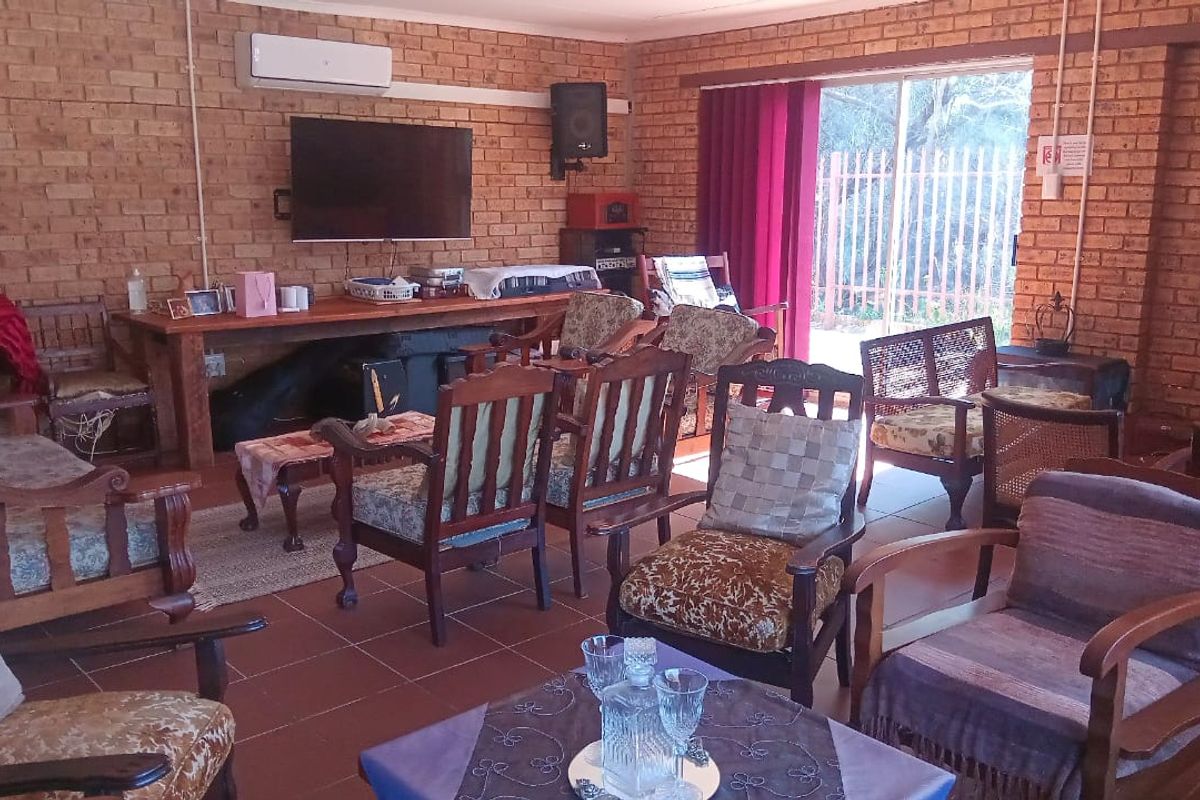 Spacious living area featuring exposed brick walls, tiled flooring, and a split-system air conditioner with direct access to the outdoor area.