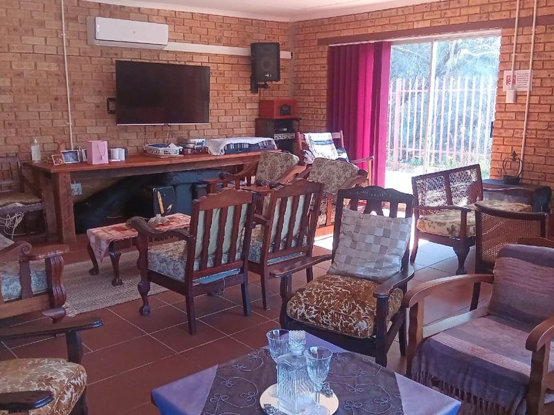 Spacious living area featuring exposed brick walls, tiled flooring, and a split-system air conditioner with direct access to the outdoor area.