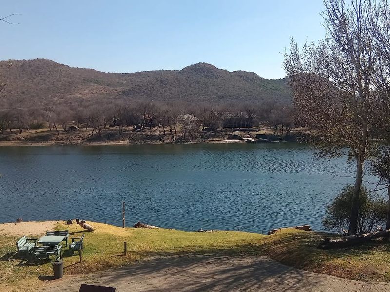 Scenic view overlooking a tranquil river with natural landscape, mature trees, and direct access to the water's edge.