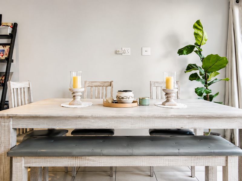 A bright dining area featuring tiled flooring and a large sliding glass door providing access to the outdoor space.