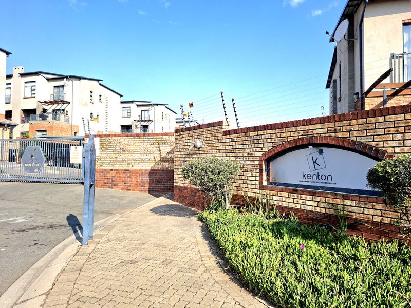 Front entrance view of Kenton complex featuring a brick boundary wall, electric fencing, and secure gated access.