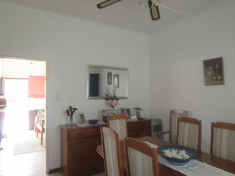 A dining room featuring a ceiling fan and access to an adjacent room.