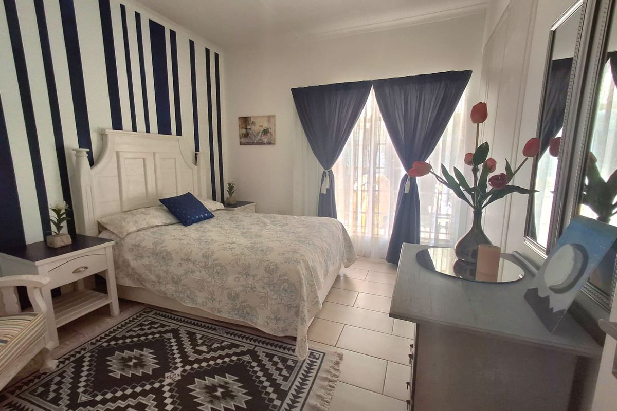A bedroom featuring tiled flooring and a sliding glass door providing natural light.