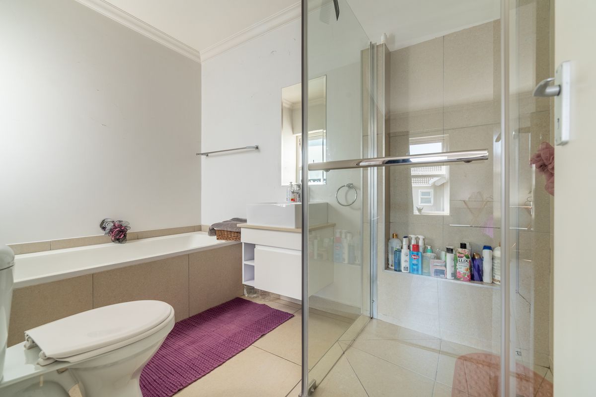 Modern bathroom featuring a built-in bathtub, a separate glass-enclosed shower with a tiled niche, and a wall-mounted vanity with a vessel sink.