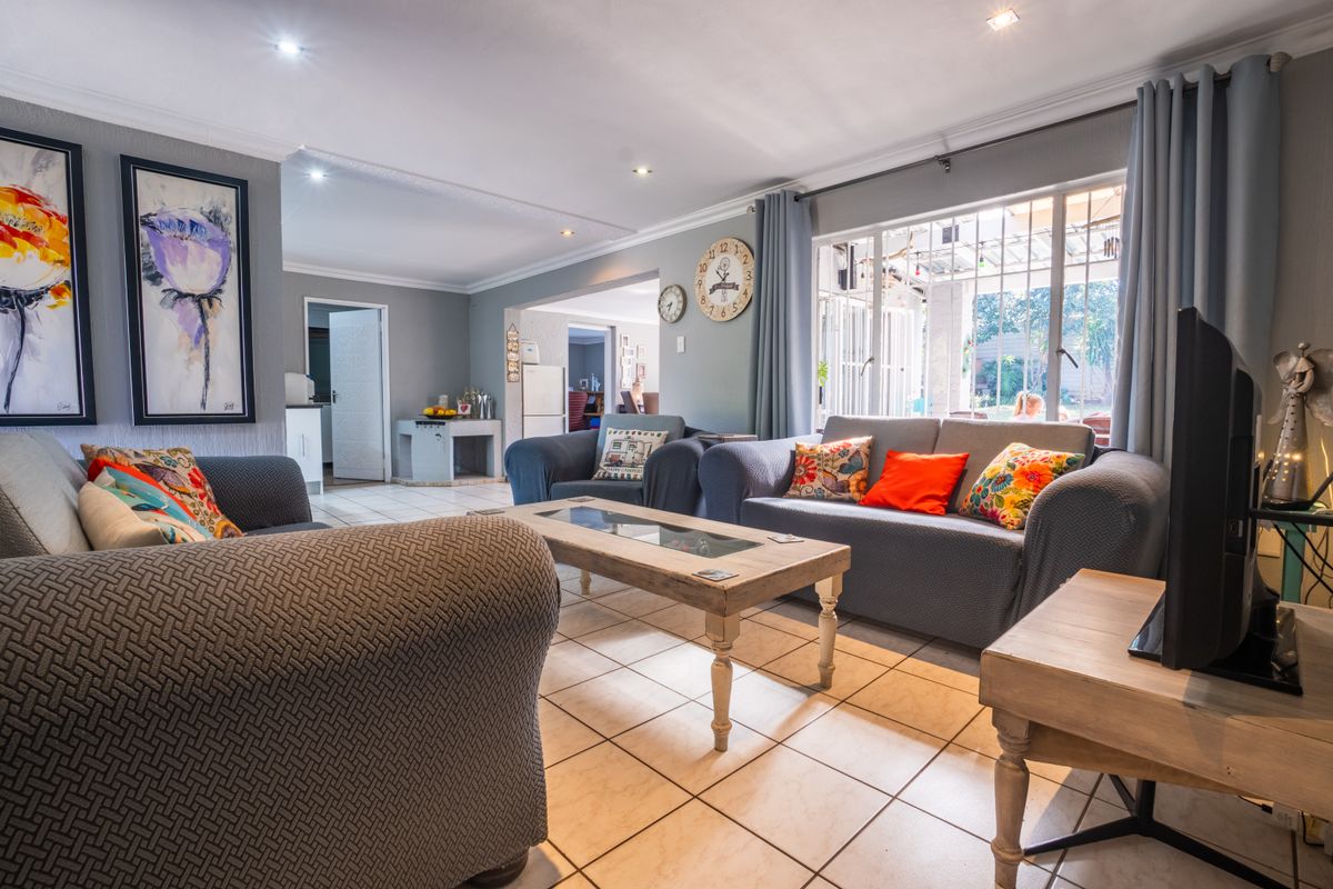 Spacious living room featuring tiled flooring, recessed downlighting, and large sliding doors providing access to the outdoor area.