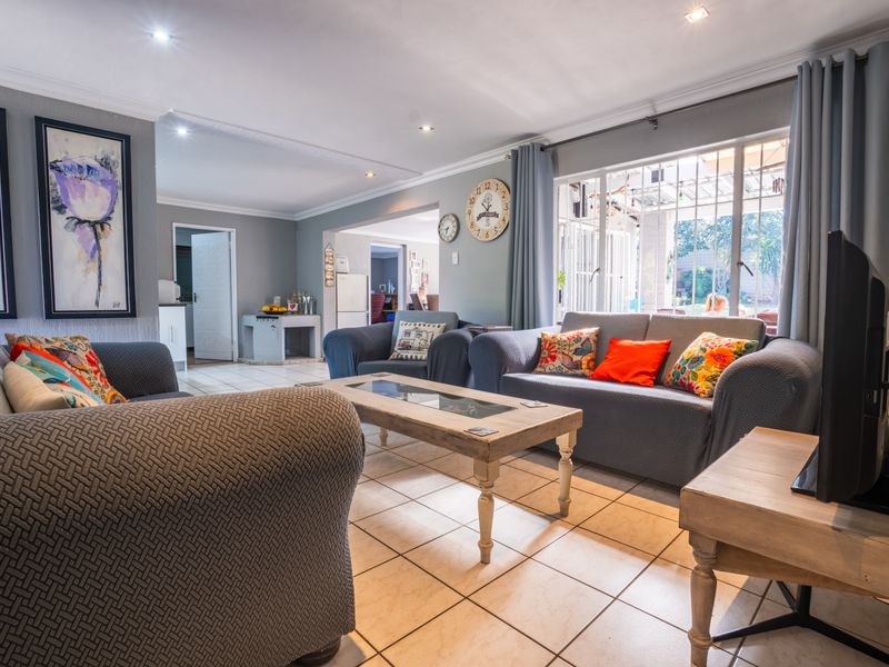 Spacious living room featuring tiled flooring, recessed downlighting, and large sliding doors providing access to the outdoor area.