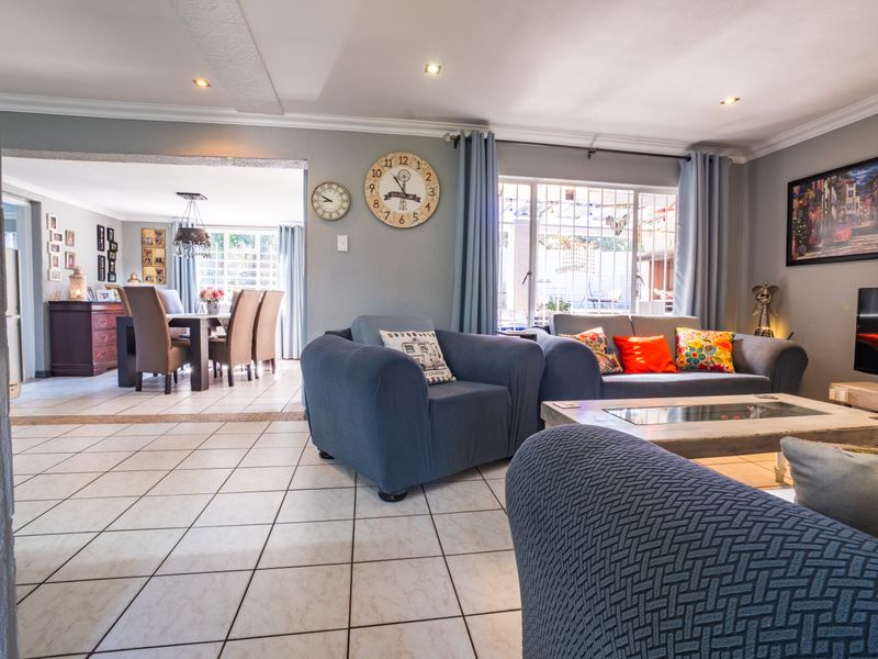 Spacious open-plan living and dining area featuring neutral tiled flooring, recessed lighting, and direct access to the outdoor patio through sliding glass doors.