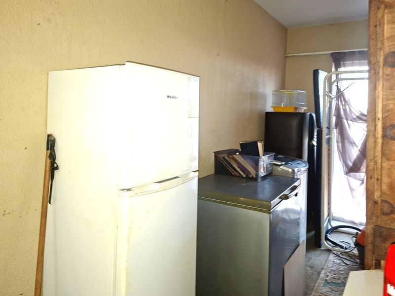 A utility or storage area featuring basic wall finishes and space for multiple appliances.