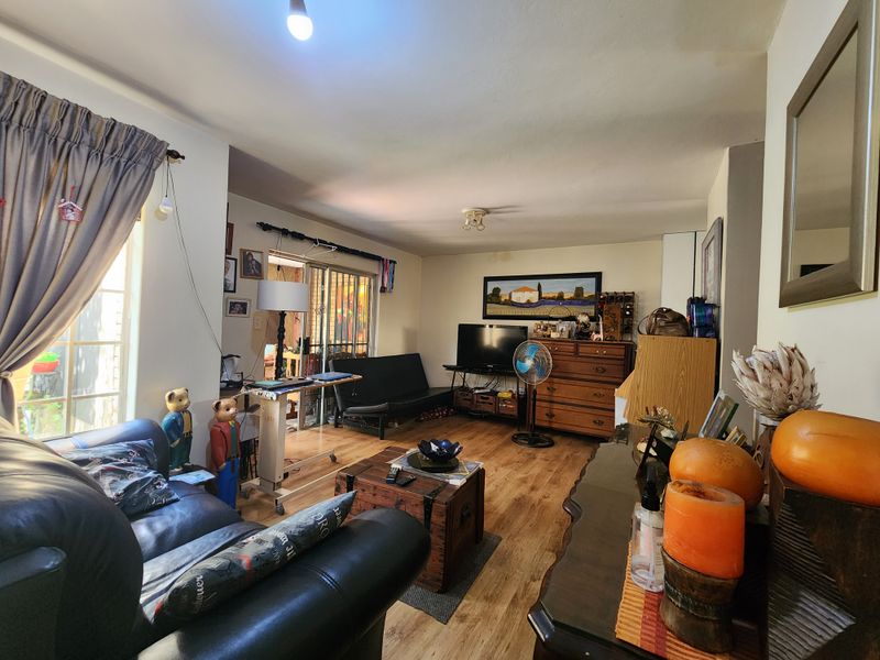 A comfortable living room featuring laminate flooring and a sliding glass door providing access to the outdoor area.